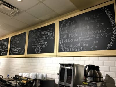 Hand-lettered chalkboard menu boards behind the espresso bar inside The Java Garden.